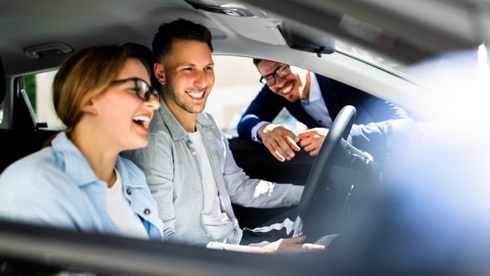 Happy car customers with salesman